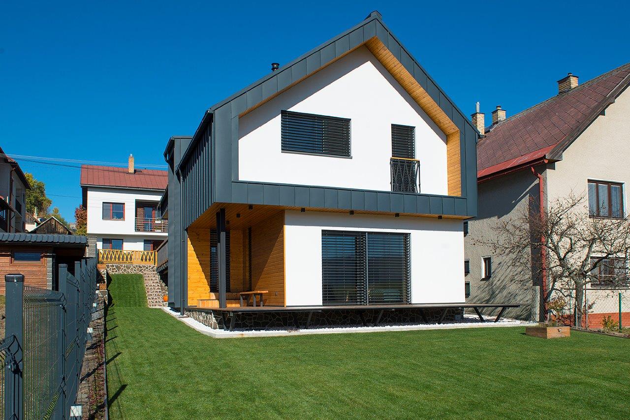 Moderný bielodrevený rodinný dom so sivou šikmou strechou v podtatranskej obci 