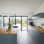 Moderná modrá kuchyňa v dome s presklením do záhrady