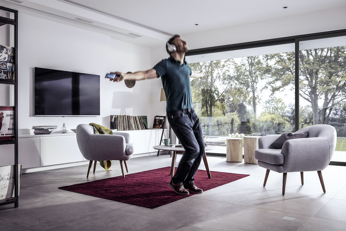 Muž so slúchadlami tancuje v obývačke