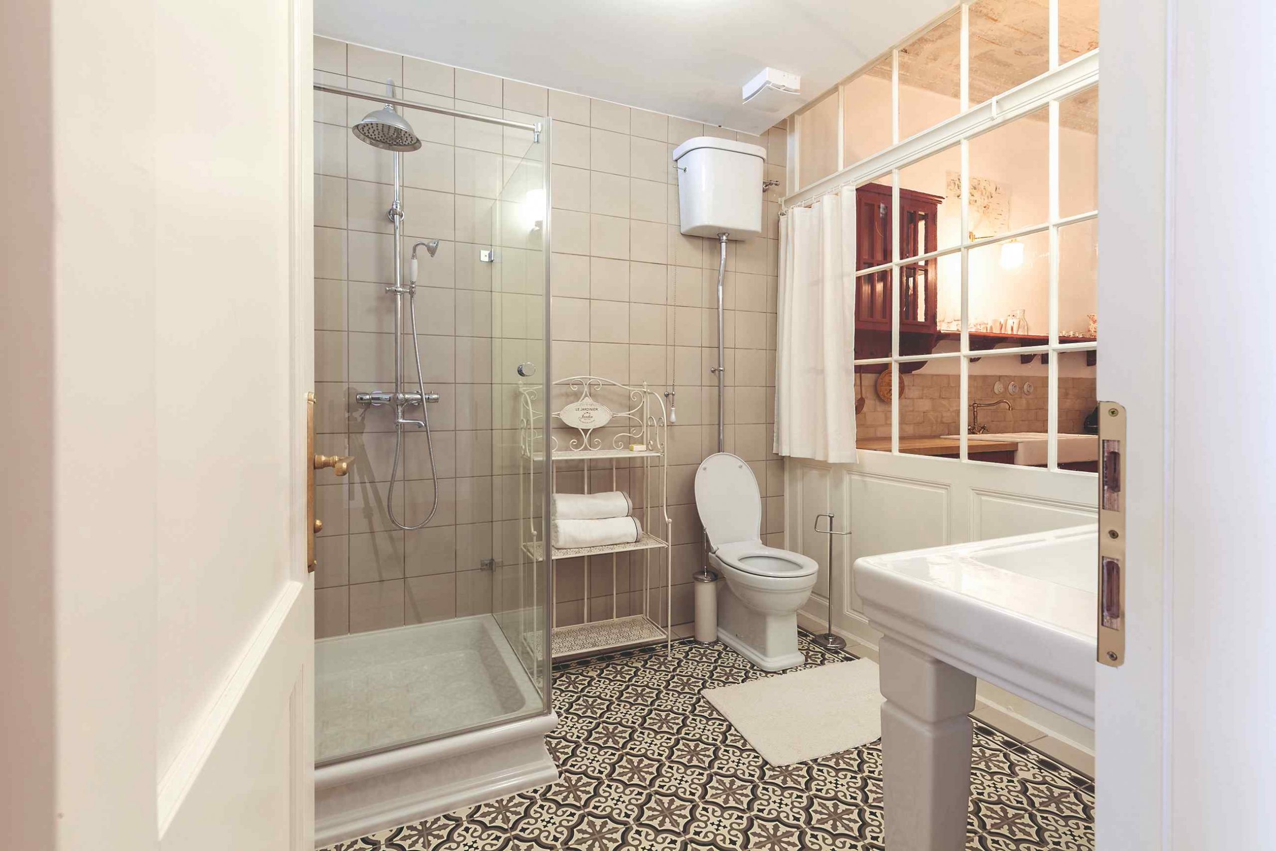 Romantické zasklené steny s nabielo natretou drevenou konštrukciou oddeľujú jednotlivé miestnosti v dvoch apartmánoch. V jednom sa tento prvok uplatnil medzi kuchyňou a spálňou, v druhom aj medzi kuchyňou a kúpeľňou.
