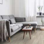 Sivý gauč s malým retro stolíkom v obývačke