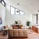Retro moderná obývačka so skosenou stenou a veľkým presklením
