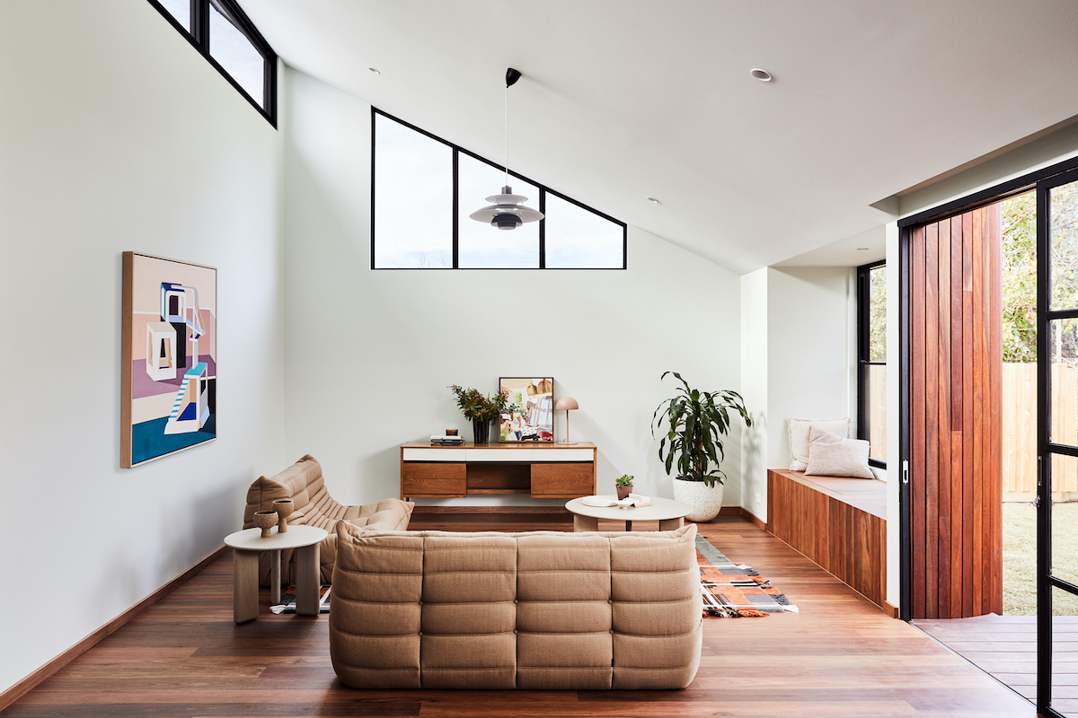 Retro moderná obývačka so skosenou stenou a veľkým presklením