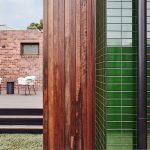 Malý ekologický moderný domček geometrických tvarov so zeleným a hnedým obkladom