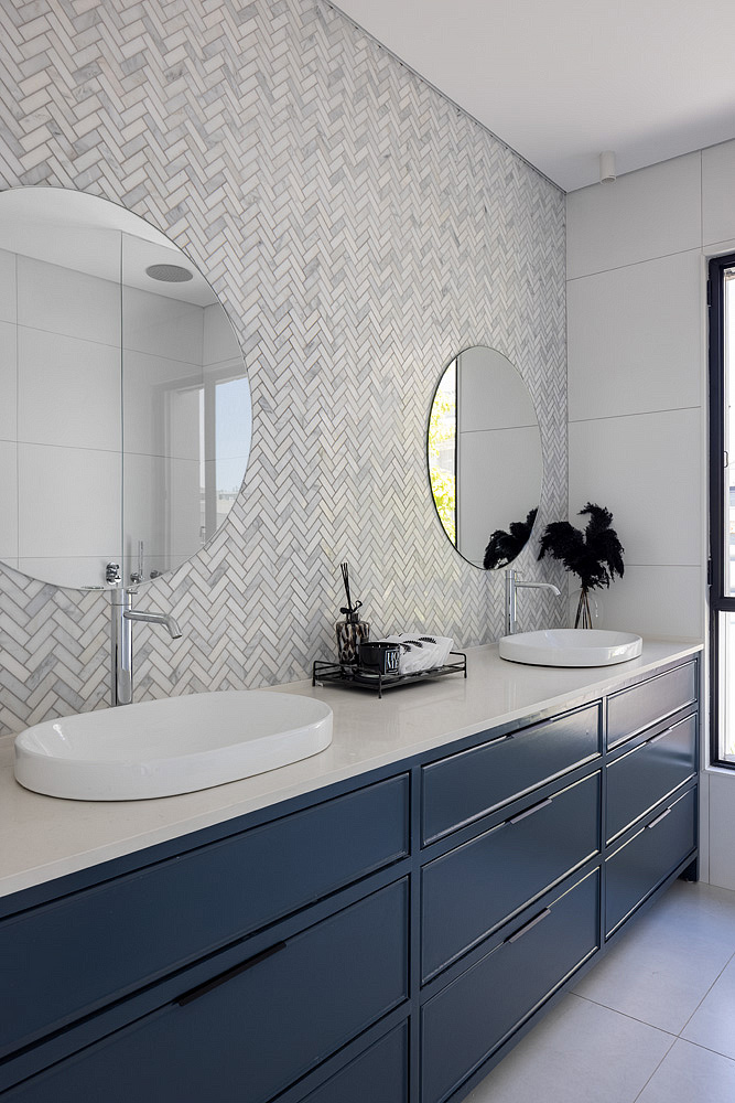 Tmavomodrá kúpeľňa so sivou mozaikovou stenou