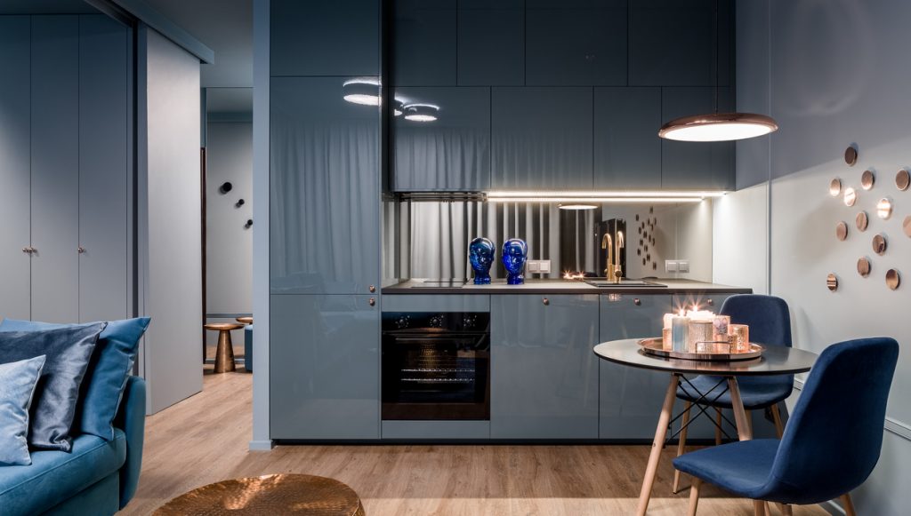 Lineárna kuchyňa v sivej v otvorenom apartmáne