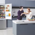 Muž so ženou v modernej kuchyni s otvorenou chladničkou