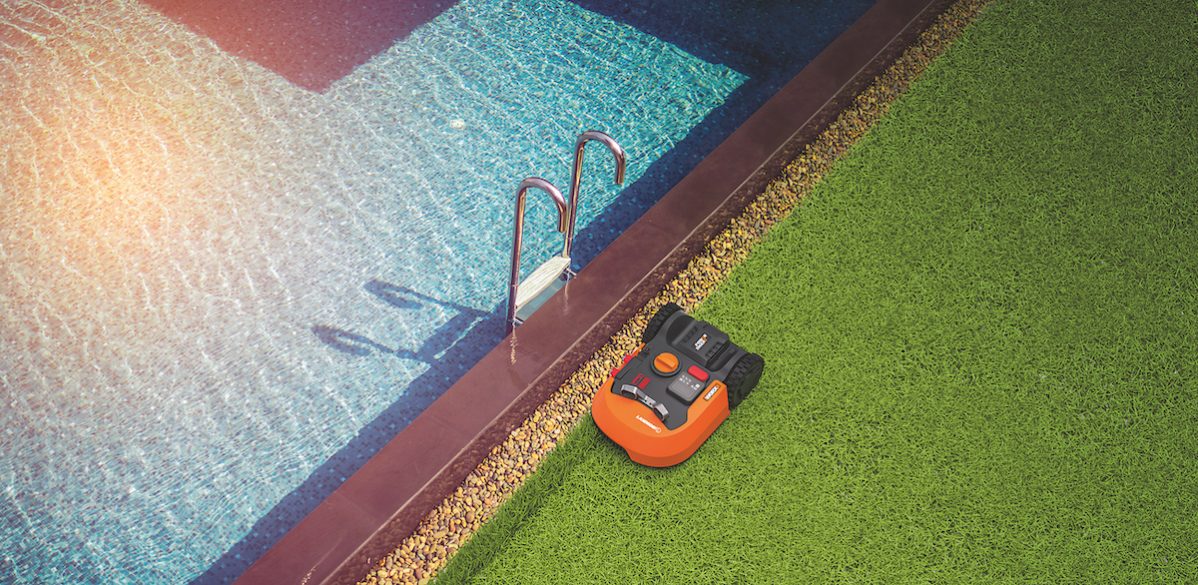 Robotická kosačka pri bazéne na trávniku