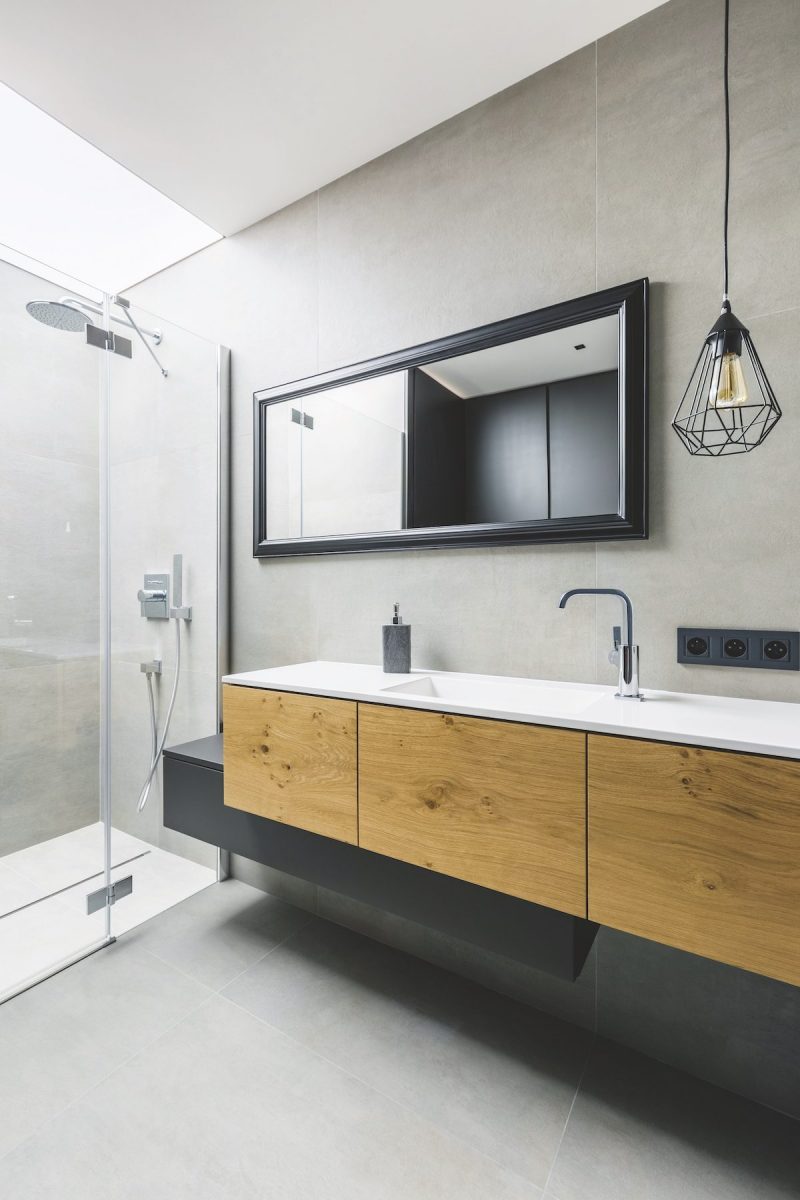 Moderná kúpeľňa so sprchou a drevenou skrinkou