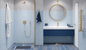 A modern bathroom in blue tones with gold fittings, a bathrobe next to the shower, a round mirror over a large washbasin with a blue cabinet, a golden heated towel rail next to a white door.
