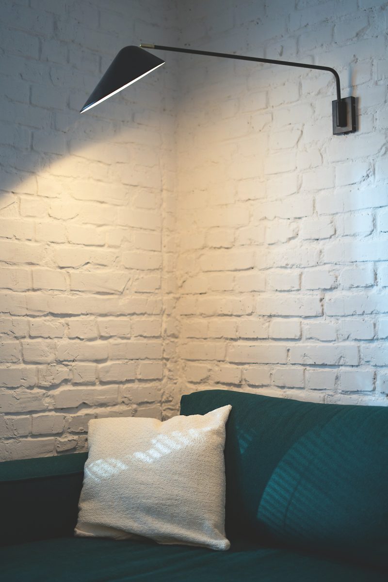 Biela tehlová stena so zeleným gaučom