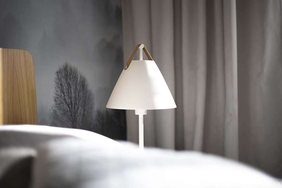 Dominantou je masívna posteľ s nočnými stolíkmi bez nožičiek a pôsobivými nočnými lampami.
