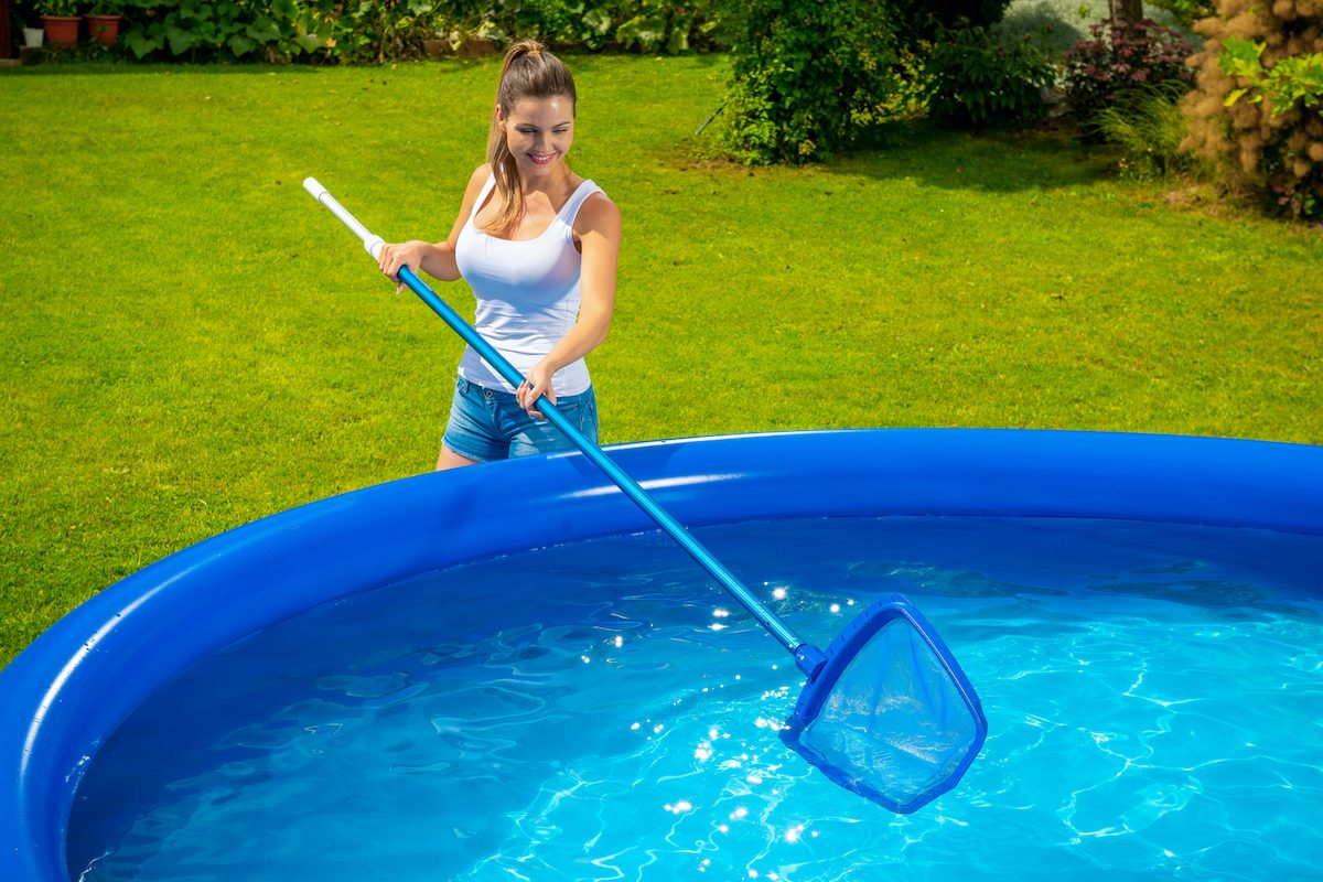 Žena čistí bazén sieťkou