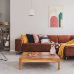 škoricový gauč s farebnými vankúšmi v modernej obývačke