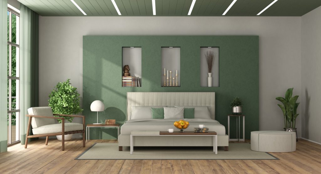 Zelená obývačka s tmavým stropom a bledým gaučom