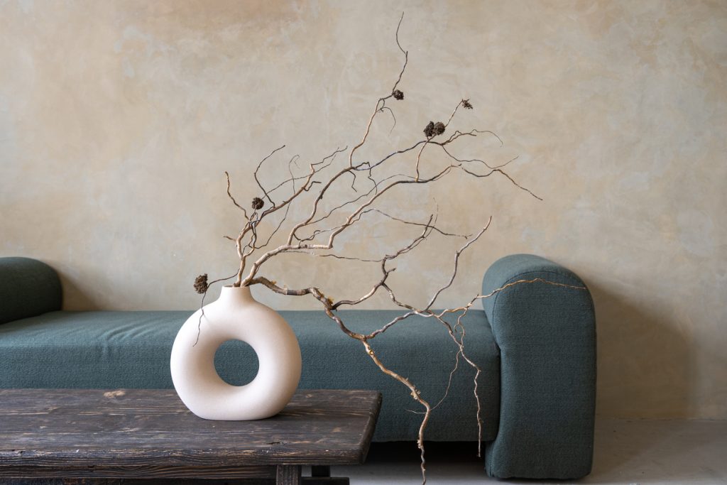 Dry branches in ceramic vase on vintage table