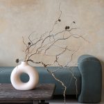 Dry branches in ceramic vase on vintage table