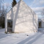Biely kanadský rodinný dom s presklením k rieke a útulným severským interiérom