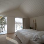 Biely kanadský rodinný dom s presklením k rieke a útulným severským interiérom