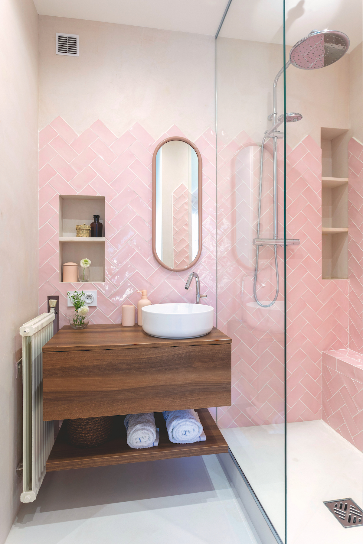 Pink herringbone tiles in small bathroom with shower