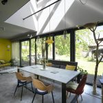 Úzka jedáleň v dome s otvoreným krovom a presklením