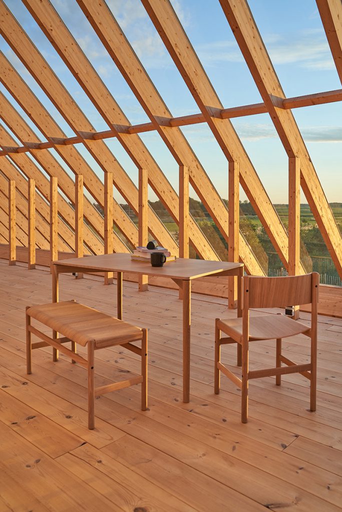 Presklené podkrovie so stolom a stoličkami- Sklenený dom v Brandenburgu