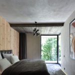 Spálňa s posteľou, obrazom a dreveným obkladom stien - Vila Nura v Rumunsku
