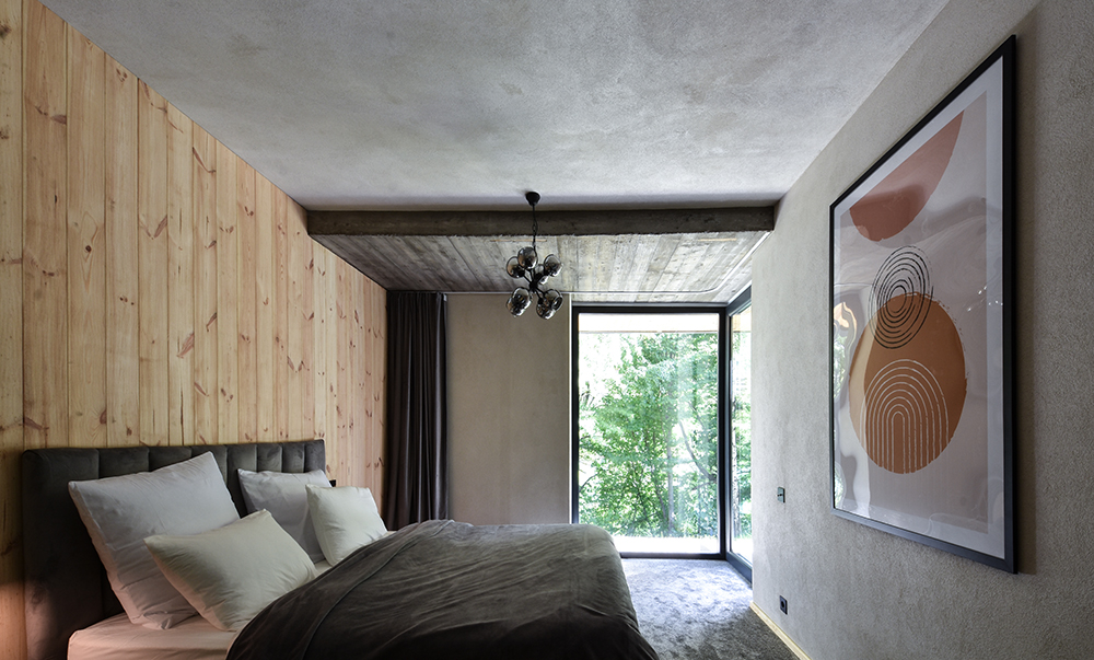Spálňa s posteľou, obrazom a dreveným obkladom stien - Vila Nura v Rumunsku