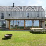 Zadná časť domu s terasou a záhradou - Drevený dom z fasádou z recyklovaného dreva v Holandsku