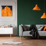 Tmavozelená stena v izbe s oranžovými doplnkami