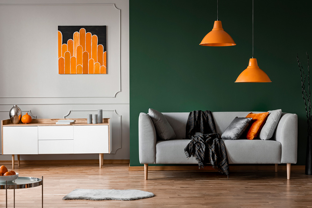 Tmavozelená stena v izbe s oranžovými doplnkami
