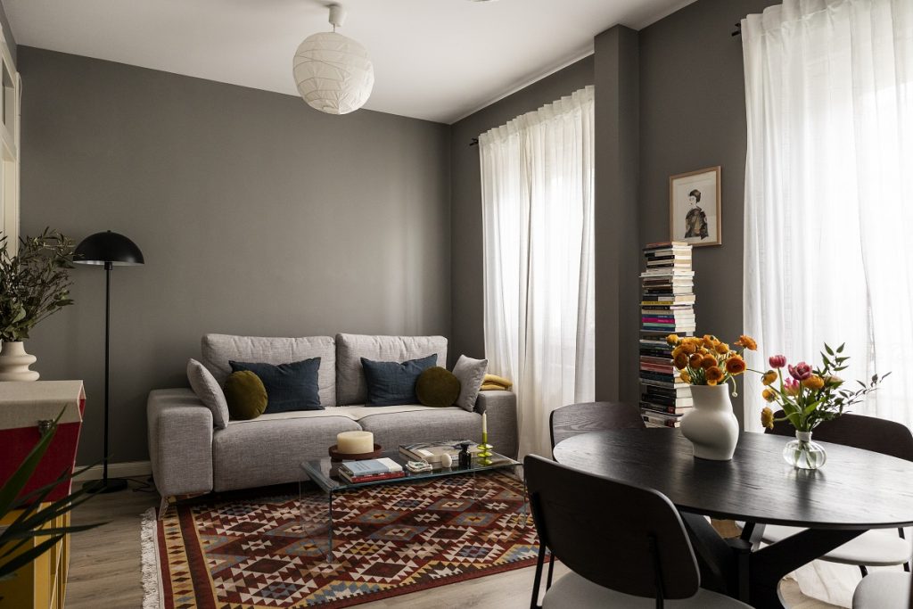 obývačka so sivou sedačkou a vzorovaným kobercom
