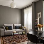 obývačka so sivou sedačkou a vzorovaným kobercom