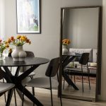 čierny jedálenský stôl a zrkadlo opreté o stenu