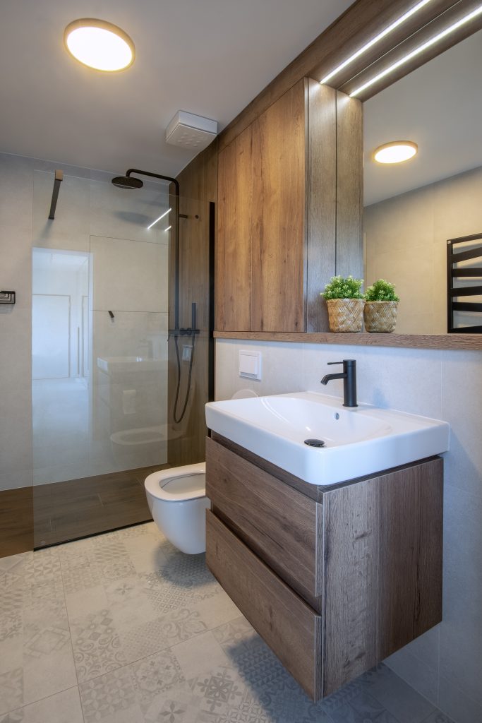 kúpelňa s dreveným dekorom, sprchovacím kútom a umývadlom