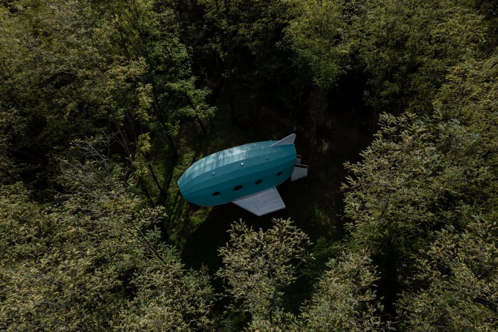 dom v tvare lietadla medzi stromami, pohľad zhora