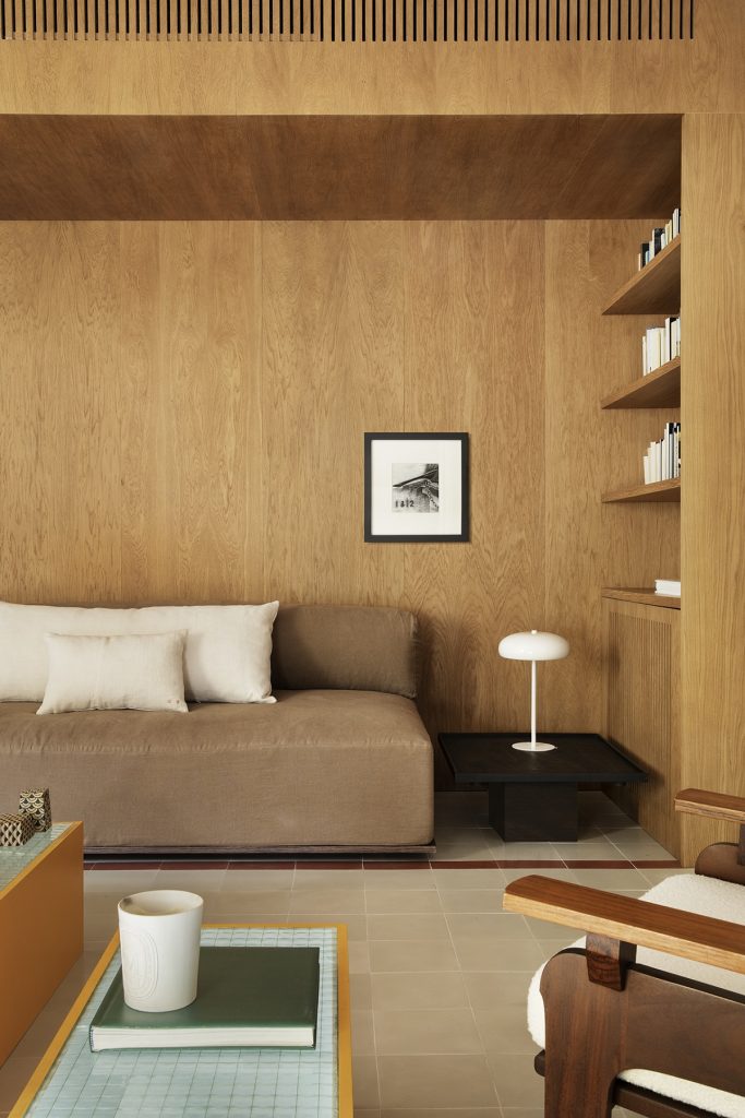 obývačka s pohovkou a knižnicou v drevenom module