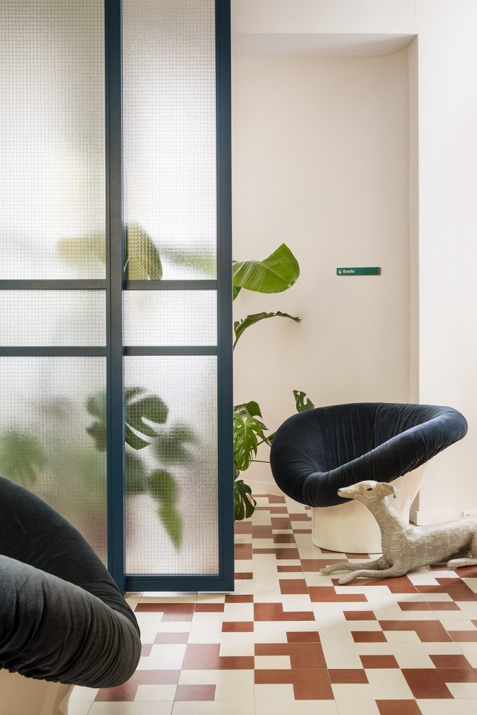 podlaha s hydraulickou bielo-bordovou dlažbou, izbové rastliny, sklenená zástena, atypická stolička
