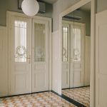 chodba s výraznou dlažbou a zrkadlom, zreštaurovane historické dvere