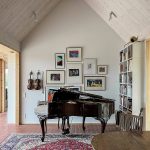obývačka s klavírom, knižnicou a fotografiami na stenách