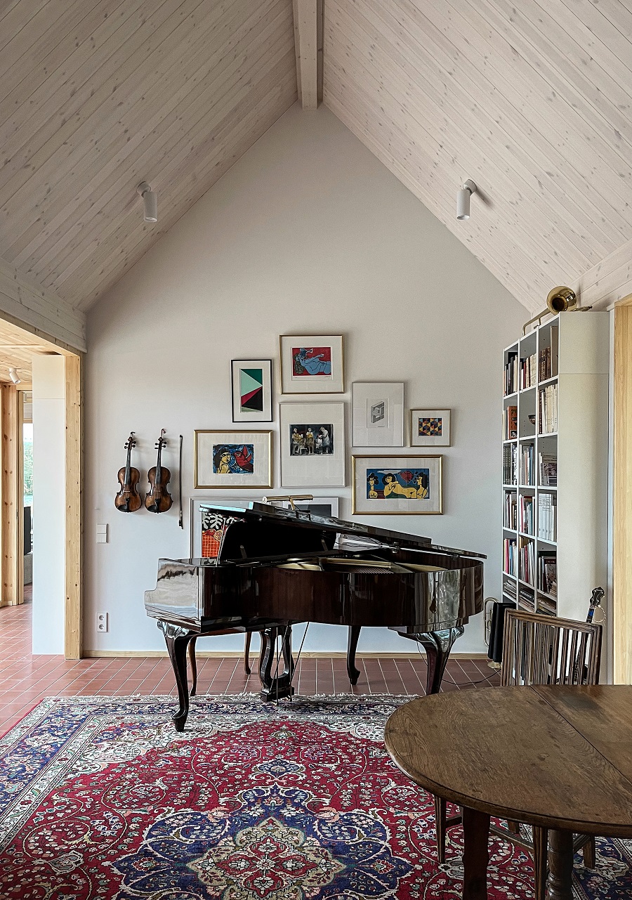 obývačka s klavírom, knižnicou a fotografiami na stenách