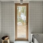 kúpeľňa s bielymi obkladačkami a čiernymi škárami, úzke dlhé okno