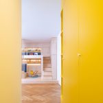 pohľad popri žltej stene do miestnosti s drevenou podlahou