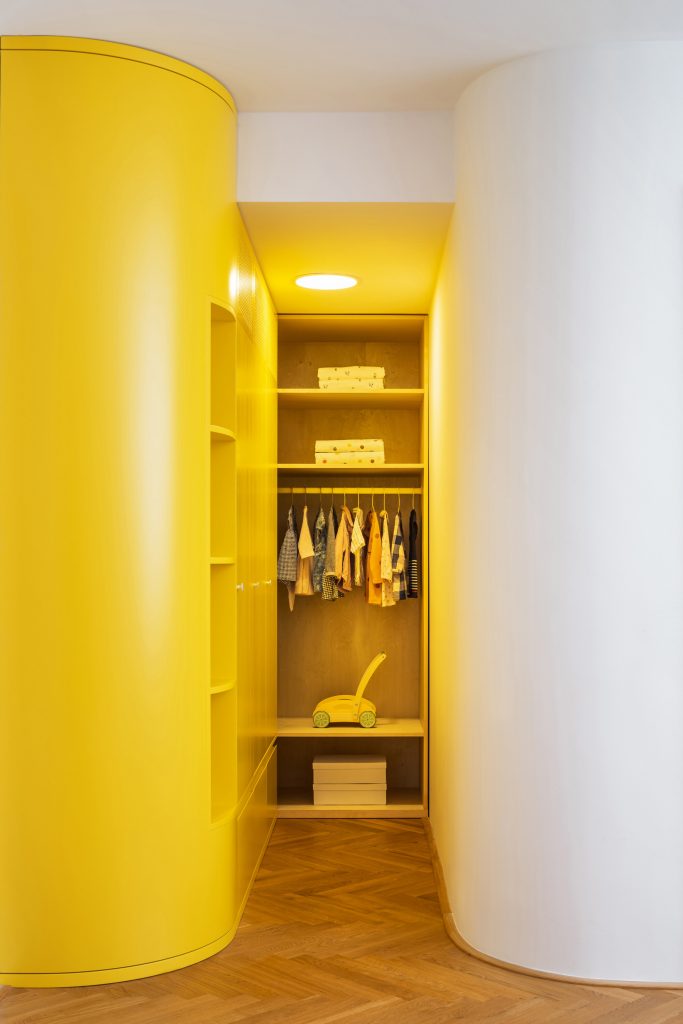 žlté osvetlenie a žltá stena šatníka pre deti