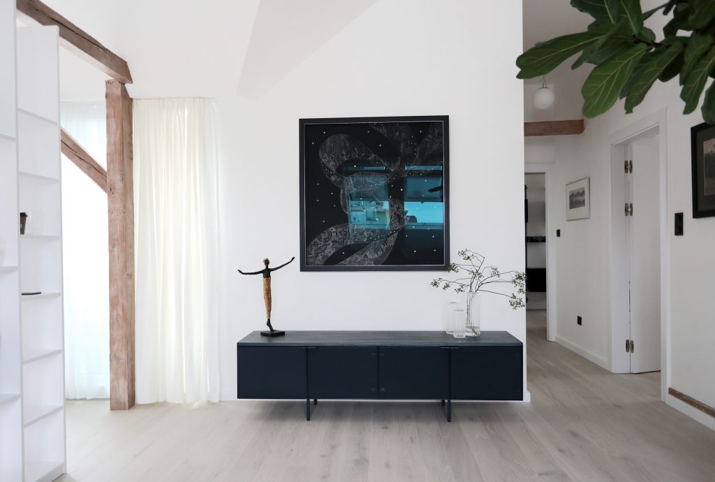 Tmavá dizajnová lavica pri bielej stene, hnedá podlaha