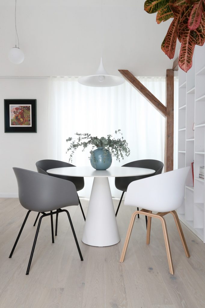 okrúhly jedálenský stôl so stoličkami bielej a sivej farby