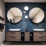 Kúpeľňa s dvomi umývadlami a dvomi zrkadlami na modrej stene