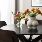 čierny stôl s vázou v tvare torza ženy, tulipány