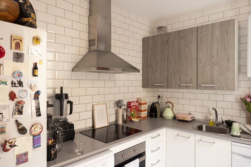 sivo-biela kuchyňa s chladničkou s magnetkami