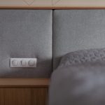detail postele so sivým čalúneným čelom